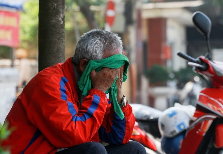 Tài xế xe ôm ở Hà Nội ngồi nghỉ dưới bóng mát trong ngày nắng nóng - TTO