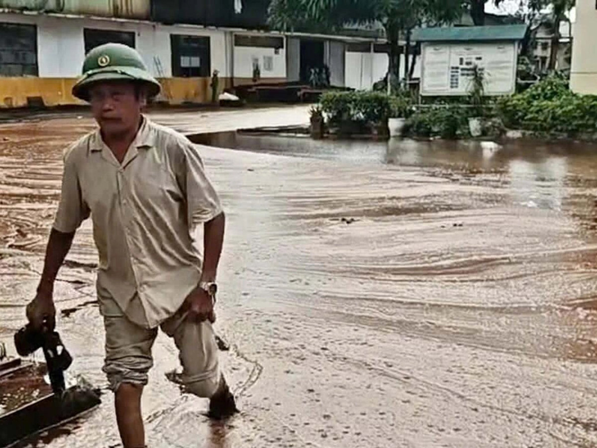 Một người lội trong dòng mật chảy tràn trên đường, sau khi bể chứa bị sét đánh Ảnh Hùng Lê