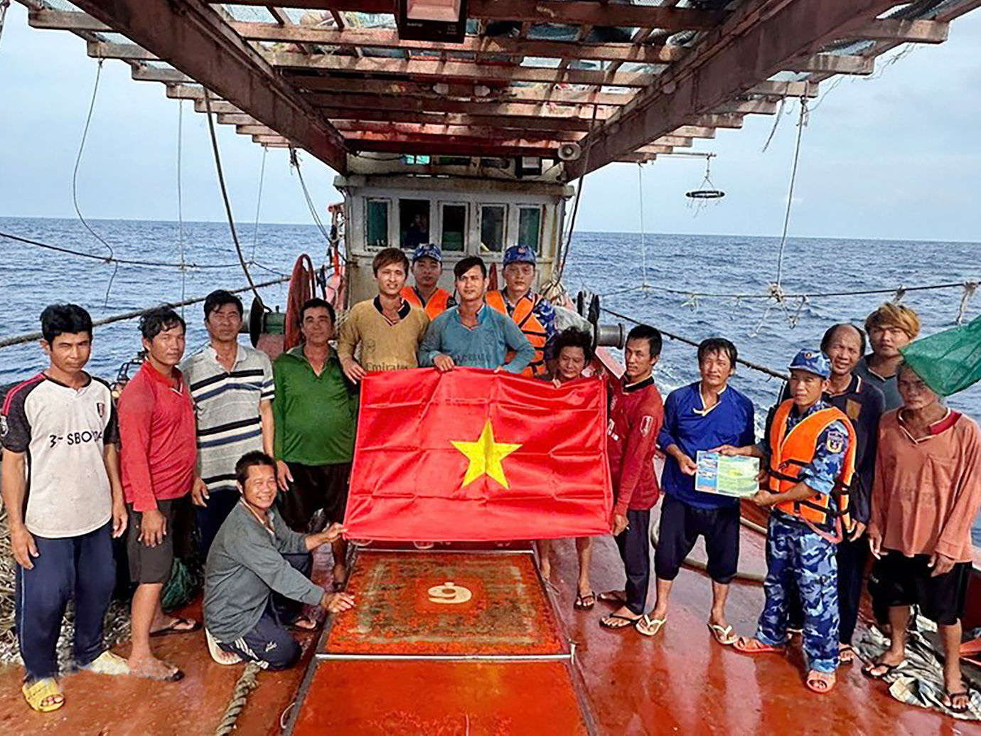 Lực lượng chấp pháp trên biển của TP.HCM trao cờ tổ quốc và tuyên truyền IUU cho ngư dân đang đánh bắt trên biển. Ảnh: TTXVN