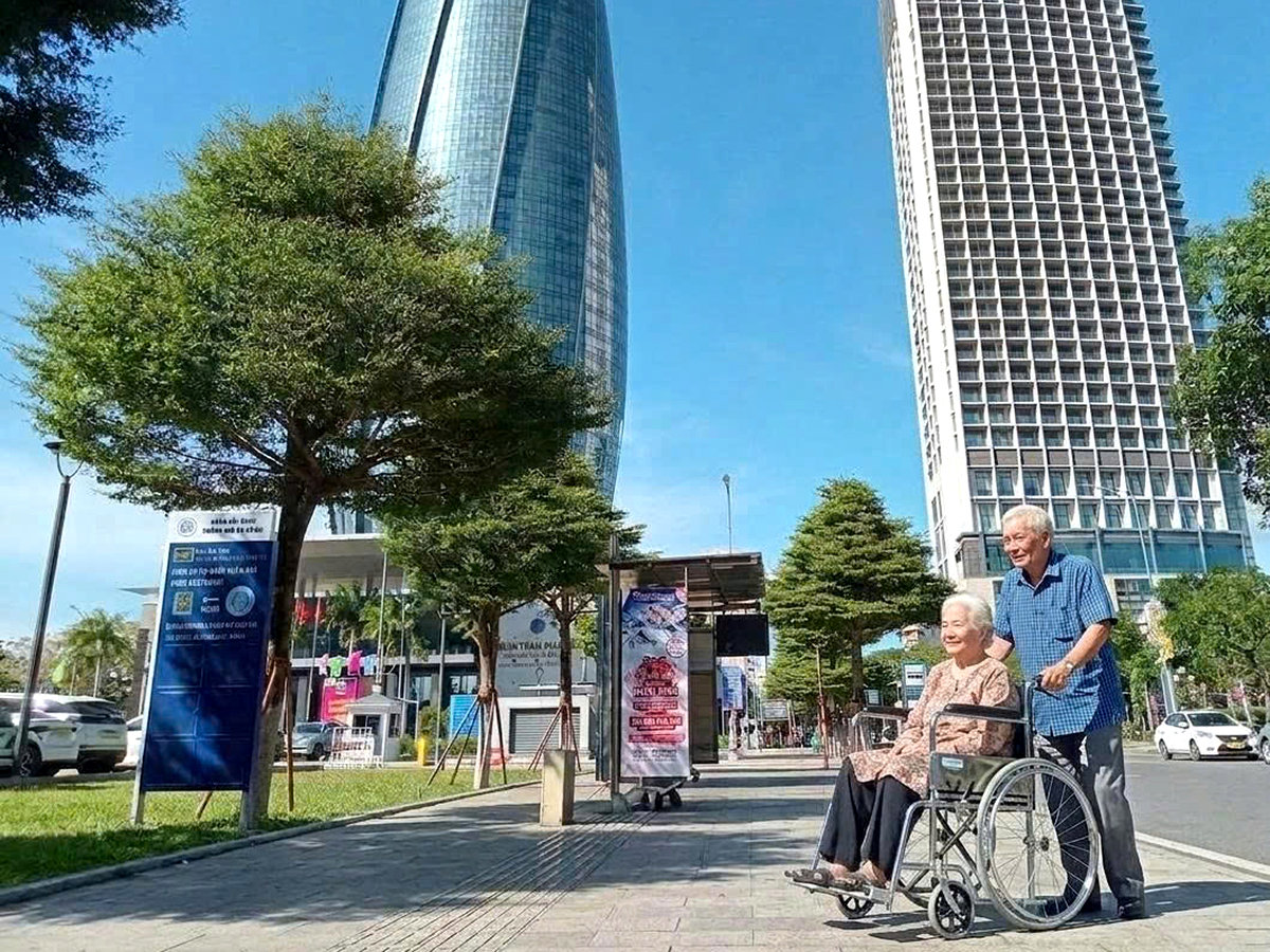 Cặp đôi du khách cao khuyết tật thong dong dạo phố xá Đà Nẵng.