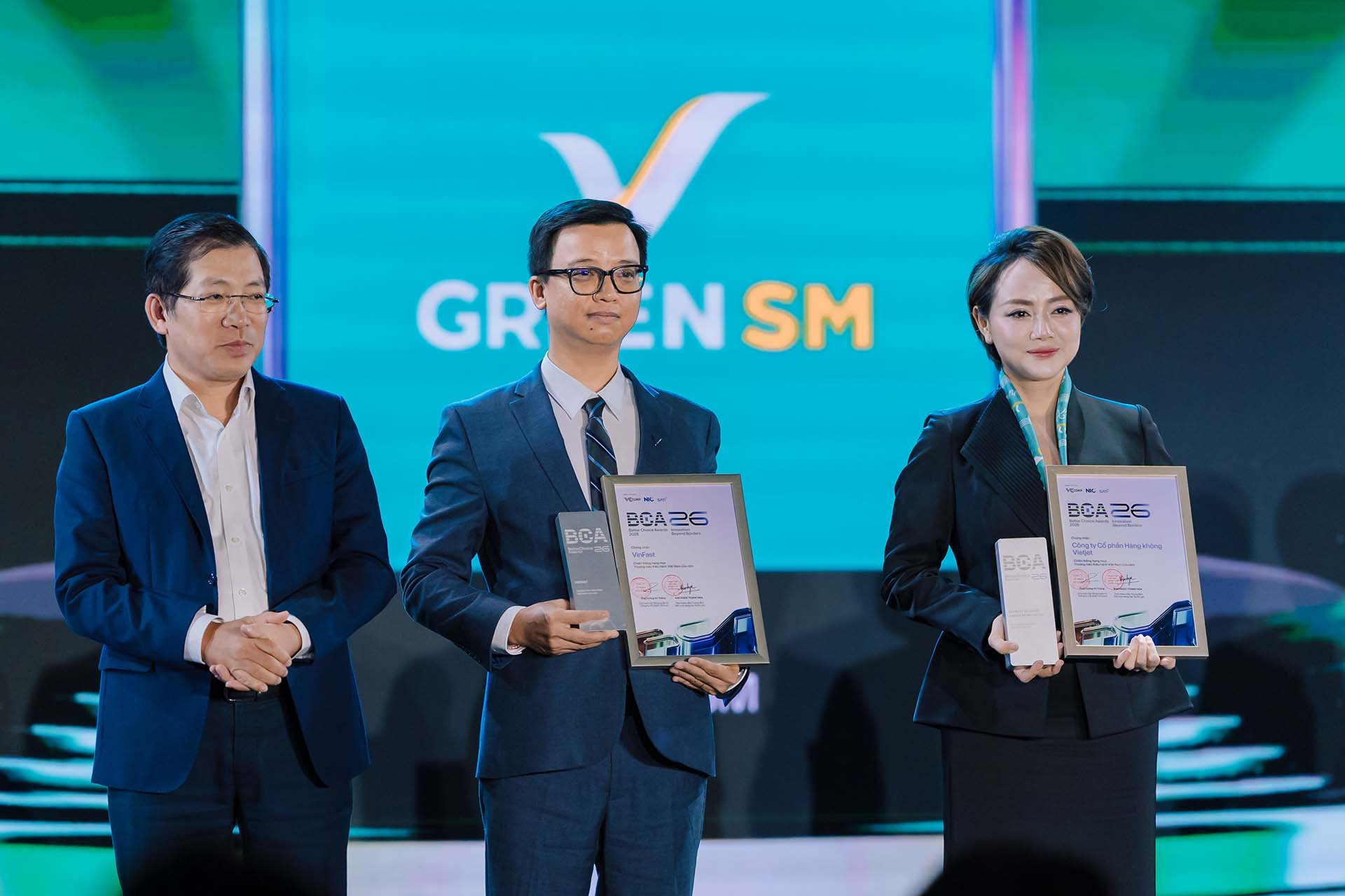 Ông Nguyễn Hồng Nhật - Tổng giám đốc VinFast Ô tô thị trường Việt Nam (giữa) và bà Trần Thanh Thủy - Phó Tổng giám đốc vận hành 2 bánh và giao hàng GSM nhận giải thưởng “Thương hiệu kiêu hãnh Việt Nam của năm” từ đại diện ban tổ chức.