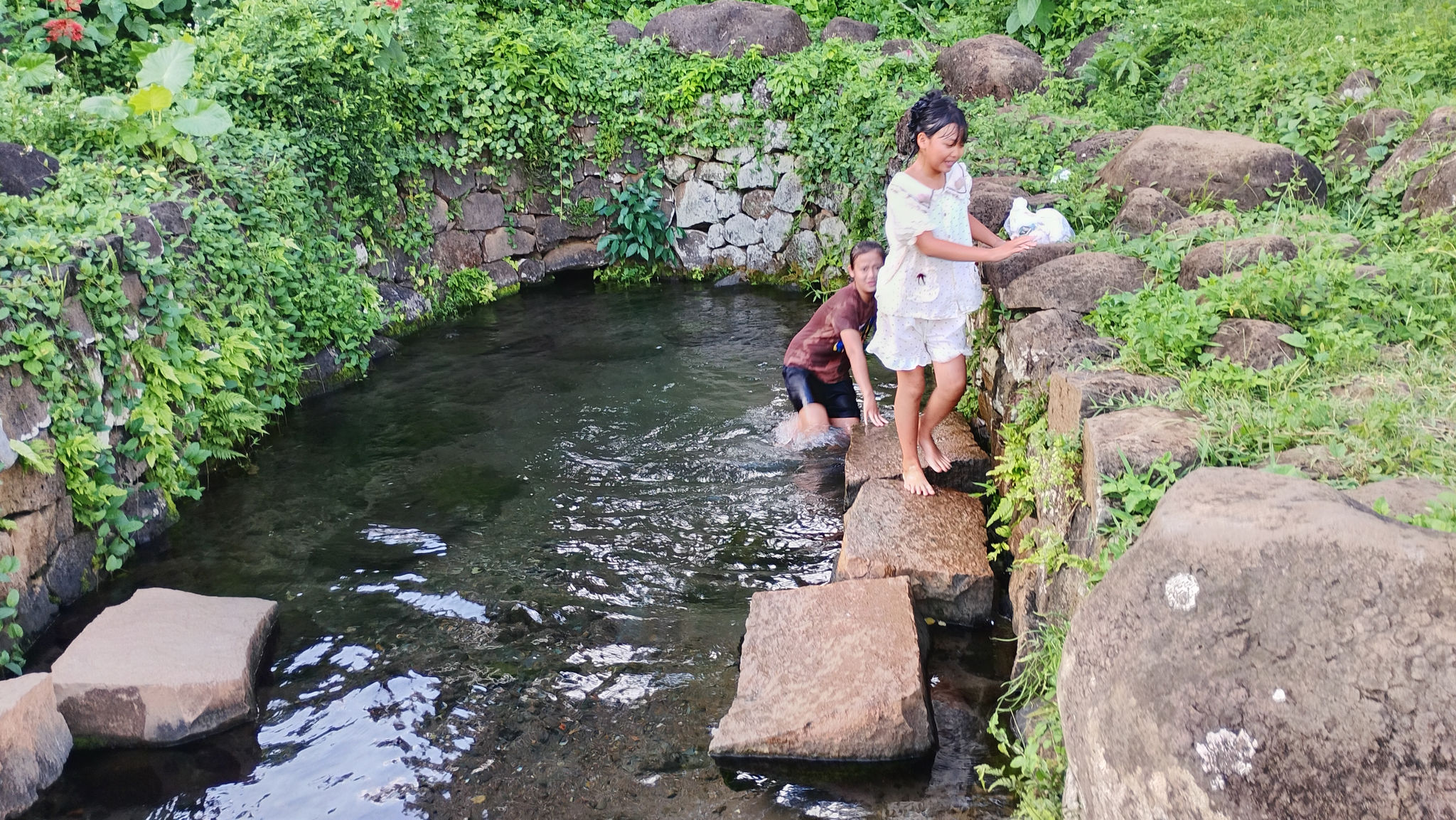 Trẻ em nô đùa bên giếng cổ.