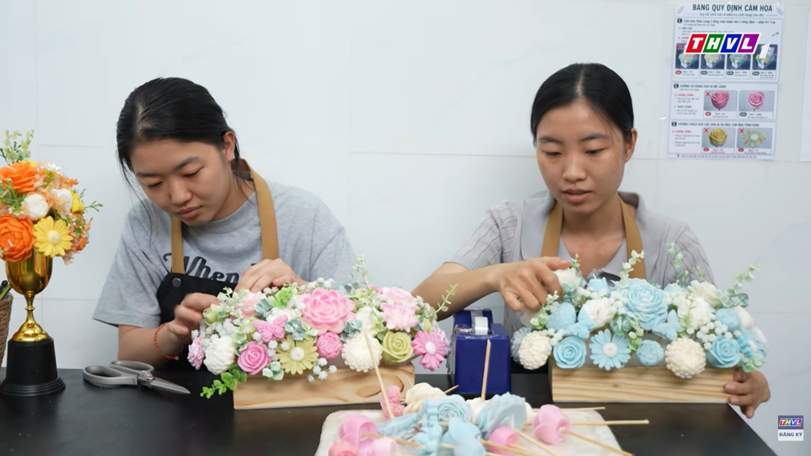 Những người thợ đang trang trí hộp hoa được làm từ nến sáp ong.